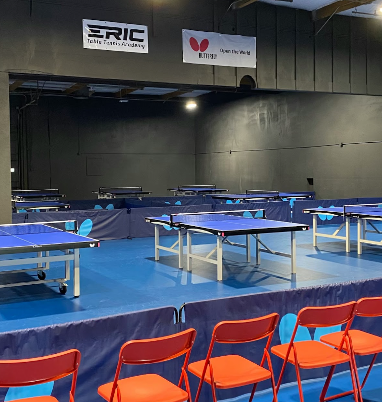 Indoor view of Eric Table Tennis Academy with empty tables ready for training.
